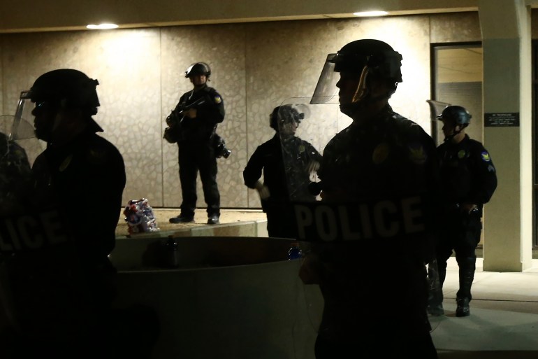 Phoenix police officers stand in front of police headquarters