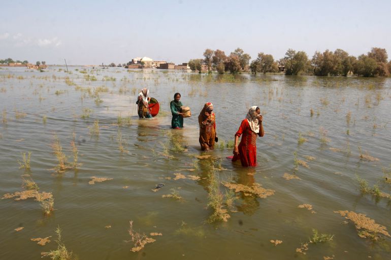 Pakistani women wade through floodwaters