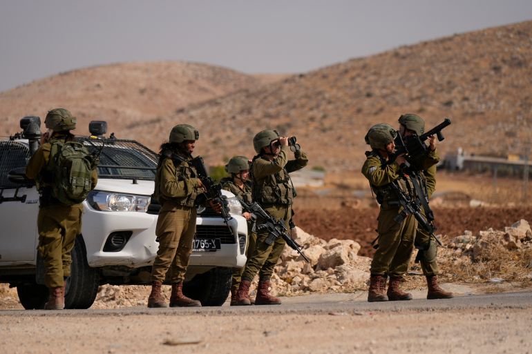 Israeli soldiers stand guard at a roadblock following a shooting attack in the West Bank in the Jordan Valley, Sunday, Sept. 4, 2022.