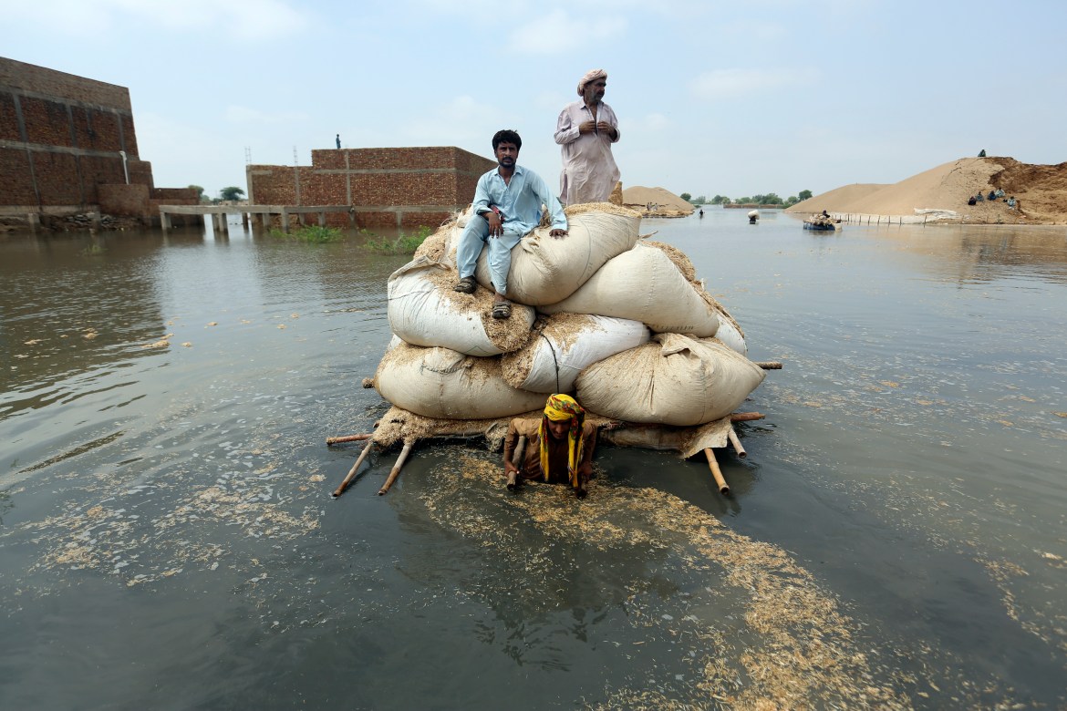 Victims of the unprecedented flooding from monsoon rains use makeshift barge to carry hay for cattle, in Jaffarabad, a district of Pakistan's southwestern Baluchistan province