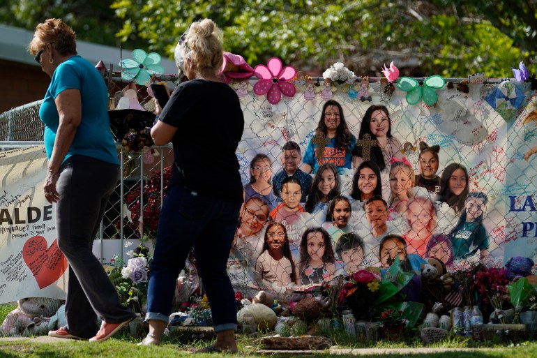 Visitors walk past a make-shift memorial at Robb Elementary School, Tuesday, Sept. 6, 2022, in Uvalde, Texas