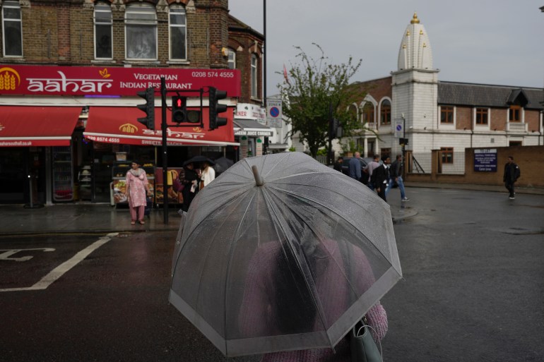 A woman walks near the Hindu temple in London's Southall district on Tuesday, September 13, 2022. At a church in an area of ​​west London known locally as Little India, a book of condolences for the Queen Elizabeth II is open.  Five days after the monarch's death, few have signed their names.  The 300-strong congregation is made up largely of the South Asian diaspora, as the majority of the estimated 70,000 people live in the Southall district, a community nestled in the outer reaches of London and built on waves of migration that have span 100 years.  (AP Photo/Kin Cheung)
