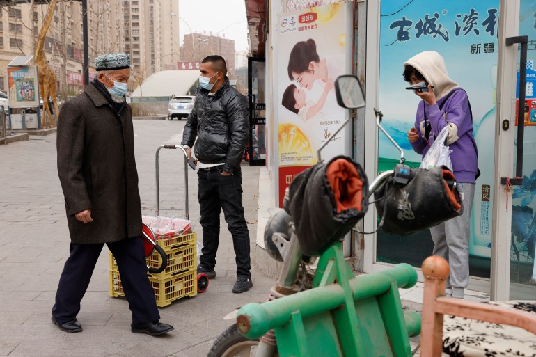 People in Aksu in Xinjiang walking the streets in masks in March 2021.