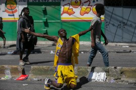 A protester kneels in Haiti