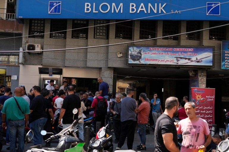 Media and security gather outside BLOM bank branch where a man who is identified as Abed Soubra is allegedly holding hostages in an effort to get to funds in his account in Beirut, Lebanon, Friday, Sept. 16, 2022. Depositors broke into at least four banks in different parts of crisis-hit Lebanon Friday demanding that they get their trapped savings as chaos spreads in the small Mediterranean nation in the middle of a historic economic meltdown. (AP Photo/Bilal Hussein)