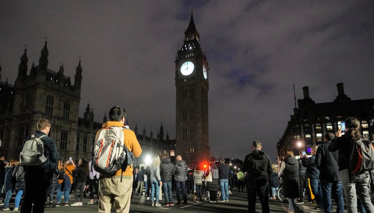 People standing on Westminster Bridge turned towards an illuminated Big Ben during a minute of silence for the queen
