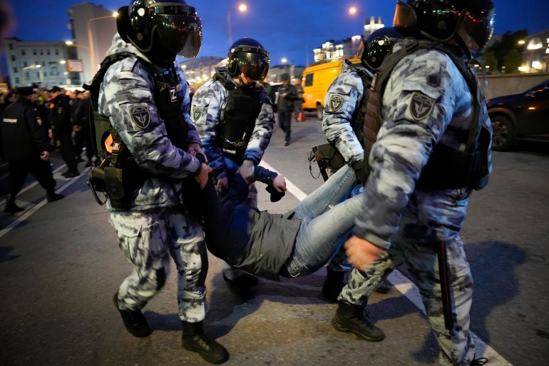 Riot police carry away a demonstrator during a protest against mobilization in Moscow, Russia.