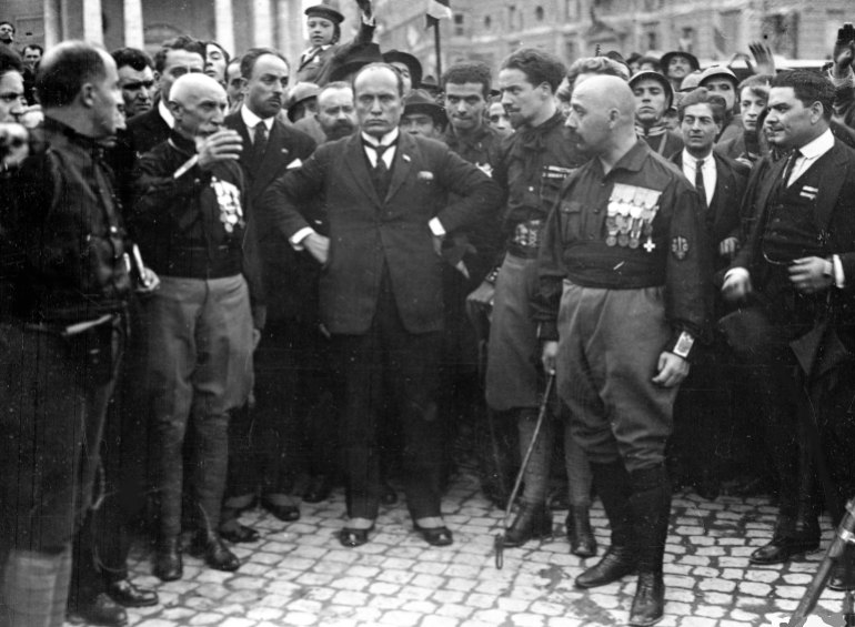 Italian fascist leader Benito Mussolini (center), hands on hips, with fascist party members, in Rome,