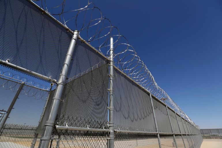 A barbed wire fence outside of an immigrant detention facility