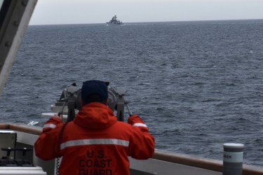 A crew member of the US Coast Guard Cutter Kimball observes one of seven foreign vessels encountered in the Bering Sea on September 19, 2022 [US Coast Guard District 17/AP]
