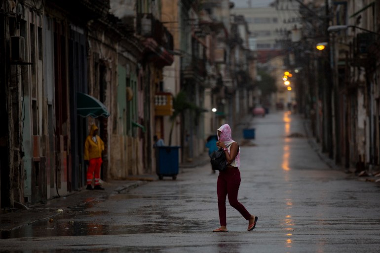 A woman crosses an empty street during the passing of Hurricane Ian in Havana, Cuba.