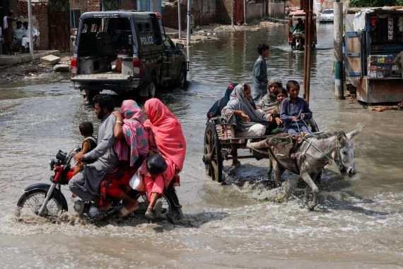 Commuters travel through flood waters in Pakistan
