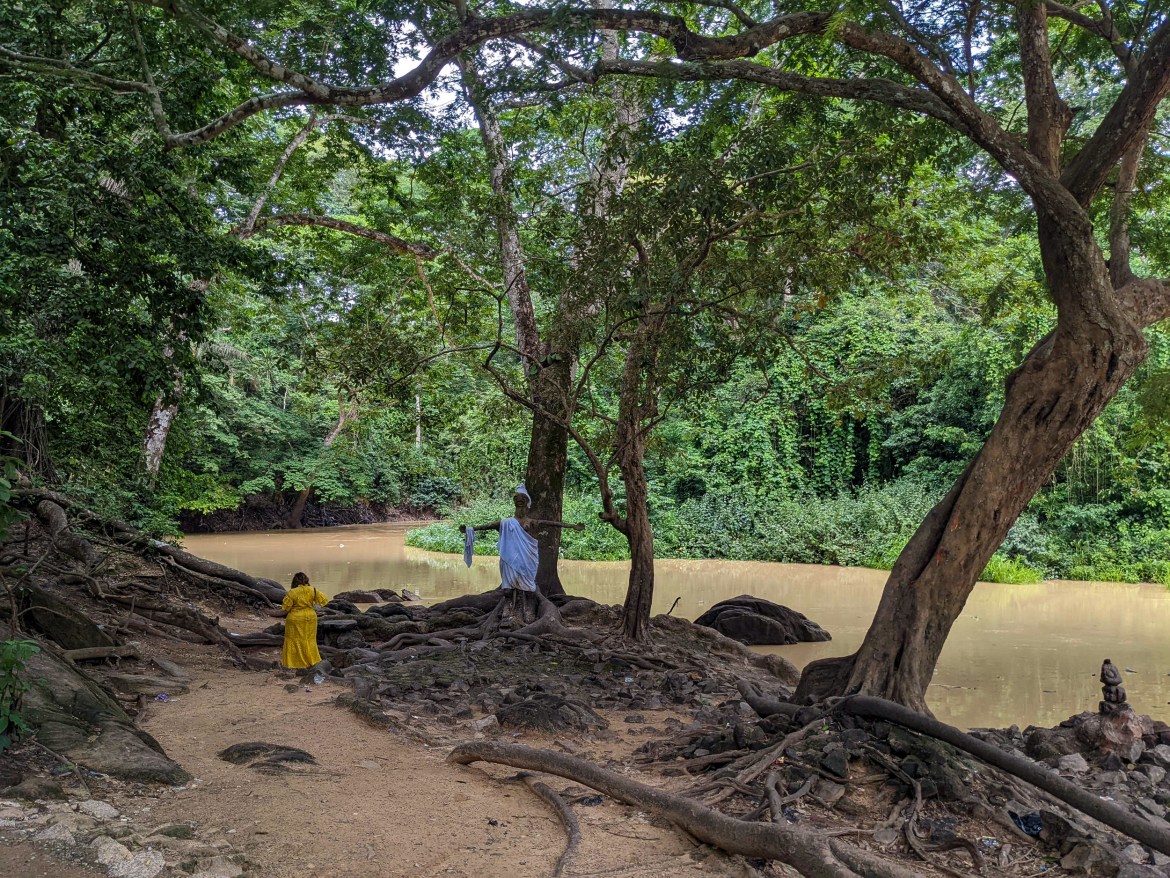 A female worshipper of Osun goes to the polluted section of the river within the sacred grove in Osogbo the state capital to pray to the goddess. [Eromo Egbejule/Al Jazeera]