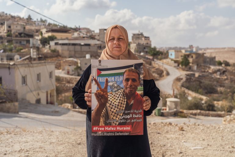 Aisha Huraini holds a photo of her husband Hafez