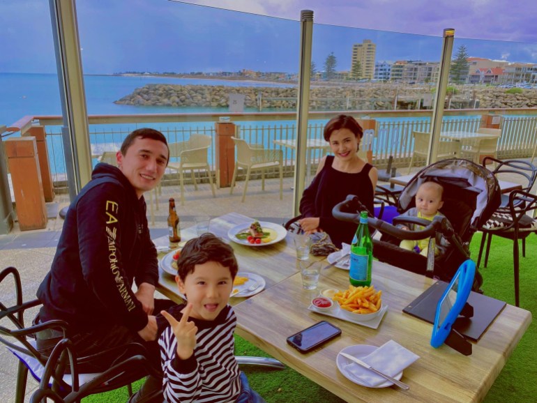 Sadam Abdusalam and Nadila Wumaier with their sons, enjoy a meal at a restaurant in Australia.