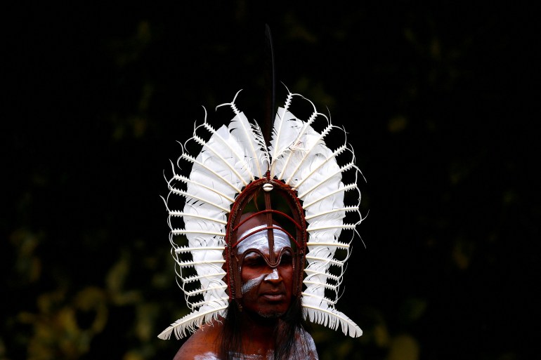 An indigenous man from the Torres Strait Islands wears a traditional dress as he performs