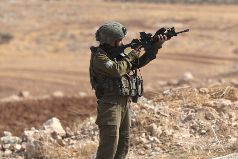 Israeli soldier pointing gun