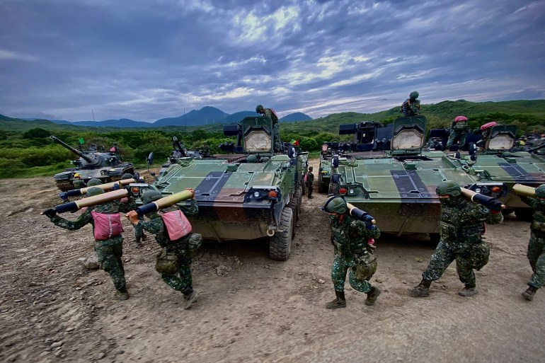 Taiwan military personnel carry ammunition in front of their tanks, during training exercises in September 2022