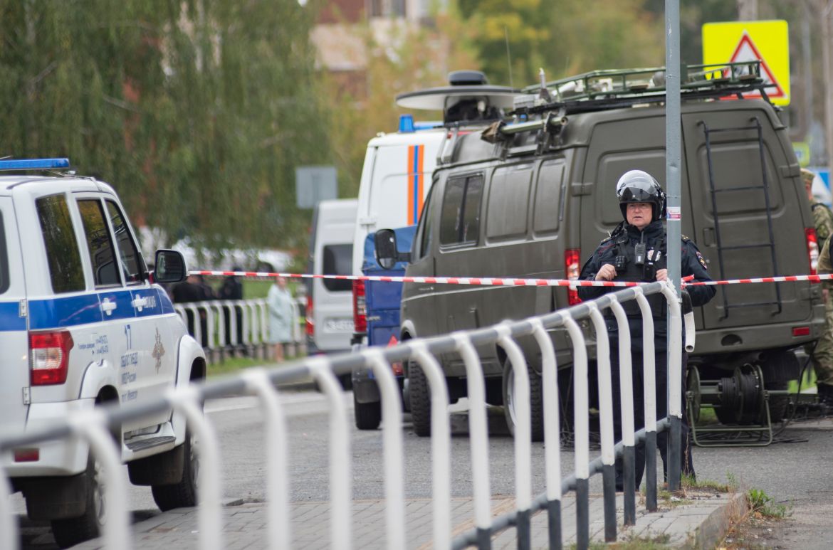 A Russian policeman stands guard behind a cordon near the scene of a school shooting.