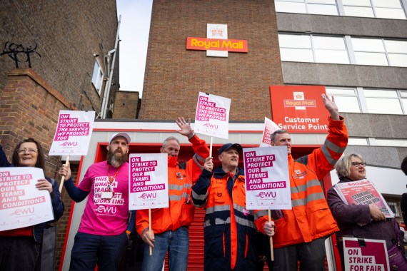 Royal Mail workers hold protest posters