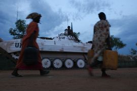 Women walk past a UN tank inside the inside de POC (protection of civilians site) in Malakal, South Sudan, on March 3rd, 2014. [Andreea Campeanu/Al Jazeera]