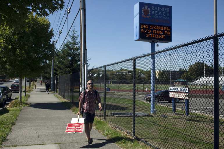 A supporter walks the picket line as teachers strike outside Rainier Beach High School in Seattle, Washington