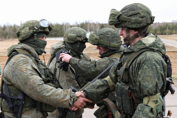 This handout video grab taken and released by the Belarussian Defence Ministry on February 19, 2022, shows Russian (L) and Belarus (R) soldiers shaking hands during joint exercises of the armed forces of Russia and Belarus as part of an inspection of the Union State's Response Force, at a firing range near Brest.