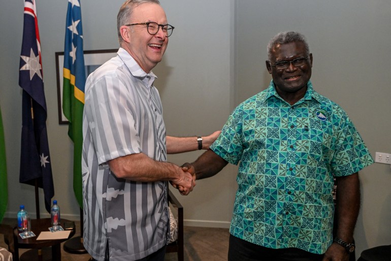 Australia's Prime Minister Anthony Albanese and Solomon Islands Prime Minister Manasseh Sogavare smile as they shake hands during a bilateral meeting at the Pacific Islands Forum in Fiji in July.