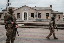 Ukrainian soldiers patrol at the recently retaken railway station in Kupiansk Vuzlovyi, Kharkiv region [Yasuyoshi CHIBA / AFP]