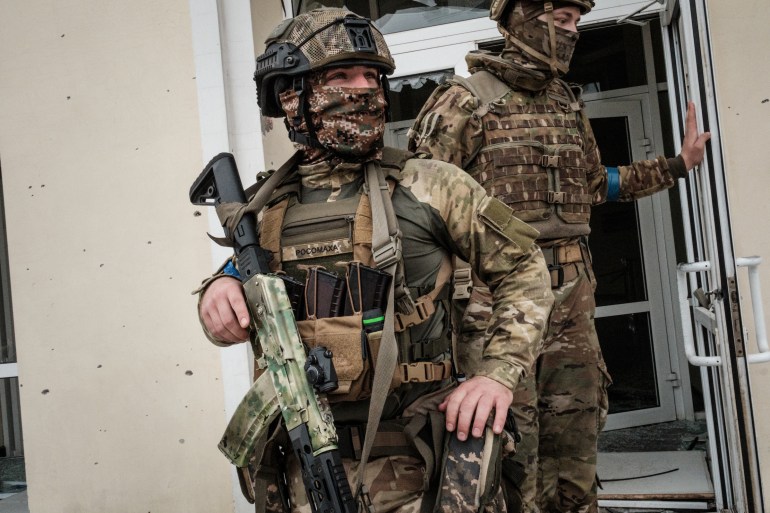 Ukrainian soldiers patrol at the recently retaken railway station in Kupiansk Vuzlovyi, Kharkiv region.