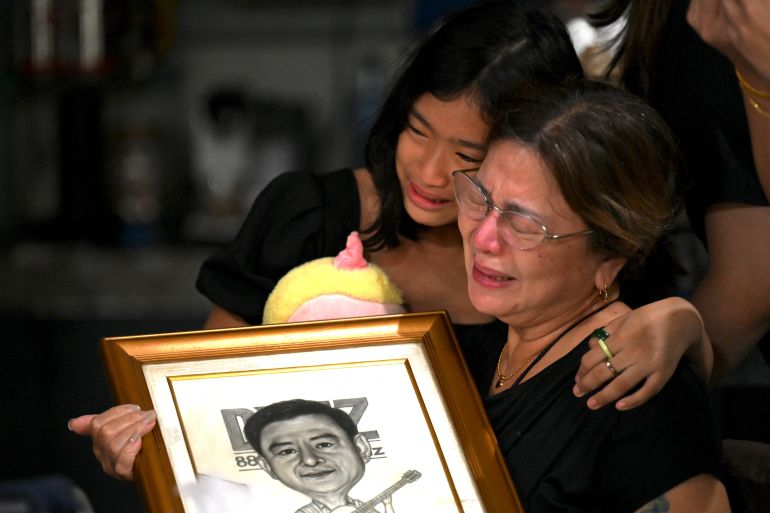Family members grieve the loss of journalist Percival Mabasa at their home in Las Pinas, suburban Manila on October 4,
