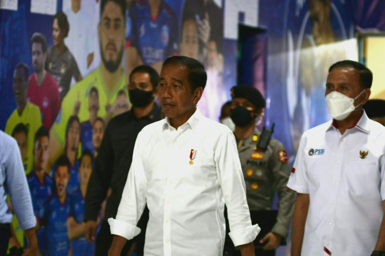 Indonesian President Joko Widodo (centre) and Indonesia's Football Association of Indonesia (PSSI) chief Mochamad Iriawan (right) visit the Kanjuruhan stadium on October 5, 2022 [AFP]