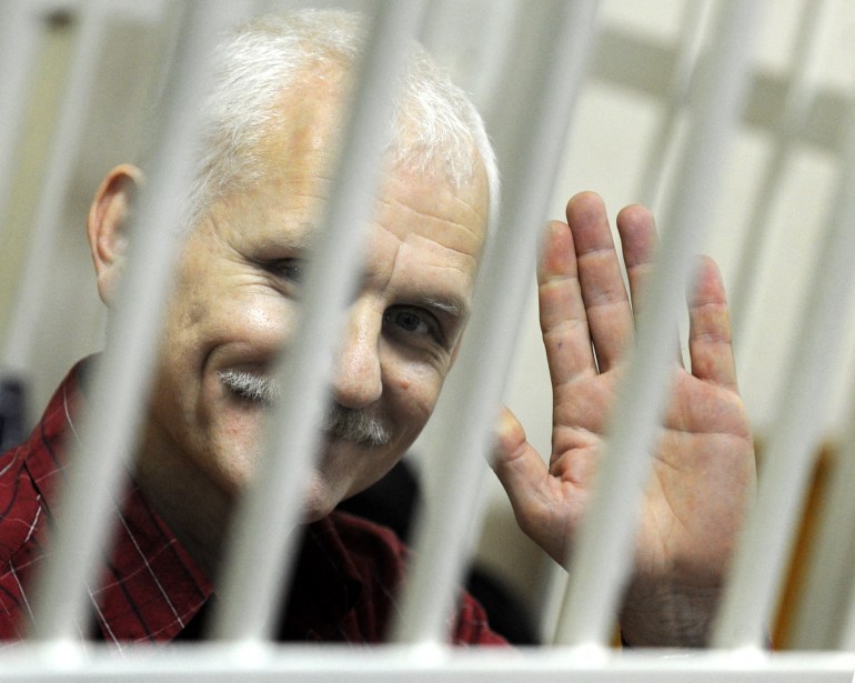(FILES) In this file photo taken on November 02, 2011 A photo taken through the bars of the defendant's cage shows the head of the Vyasna (Spring) rights group, Ales Beliatsky, in a Minsk court.  - The Norwegian Nobel Committee awarded the 2022 Nobel Peace Prize to human rights defender Ales Bialiatski from Belarus, the Russian human rights organization Memorial and the Ukrainian human rights organization Center for Civil Liberties.  (Photo by VIKTOR DRACHEV / AFP)