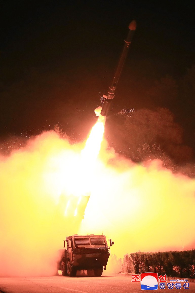 a cruise missile taking off from a launcher in a cloud of smoke and flame