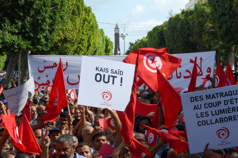Islamist Ennahda party supporters wave the national flag during a demonstration against Pesident Kais Saied in the capital Tunis on October 15, 2022. (Photo by Fethi Belaid / AFP)