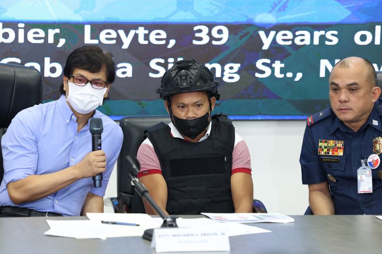 Joel Estorial (centre), the alleged gunman in the killing of Philippine journalist Percival Mabasa, is presented to the media on October 18, 2022 [AFP]