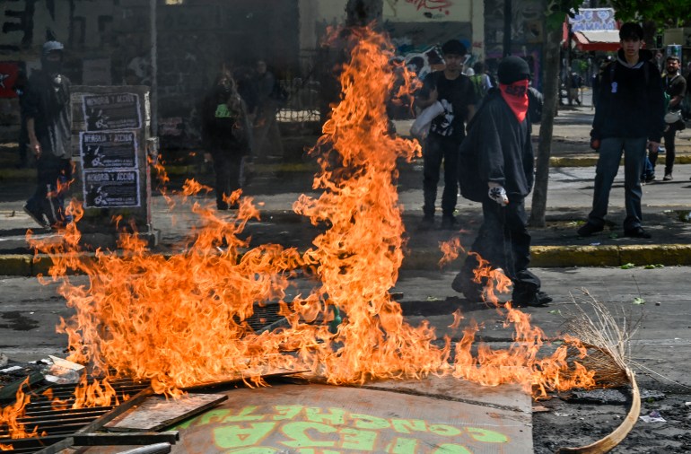 Street with barricade lying on the ground in flames 