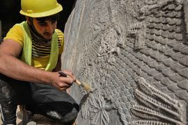 An Iraqi worker excavates a rock-carving relief recently found at the Mashki Gate