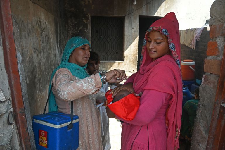 A health worker administers polio vaccine drops to a child during a vaccination campaign in Lahore on October 24, 2022