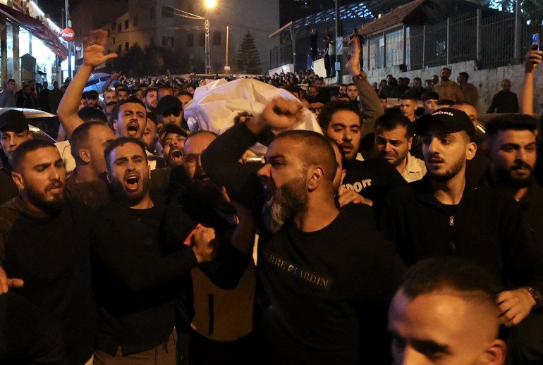 The body of a Palestinian man killed by Israeli troops is carried in Nablus in the occupied West Bank in the early hours of October 25, 2022 [Jaafar Ashtiyeh/ AFP]