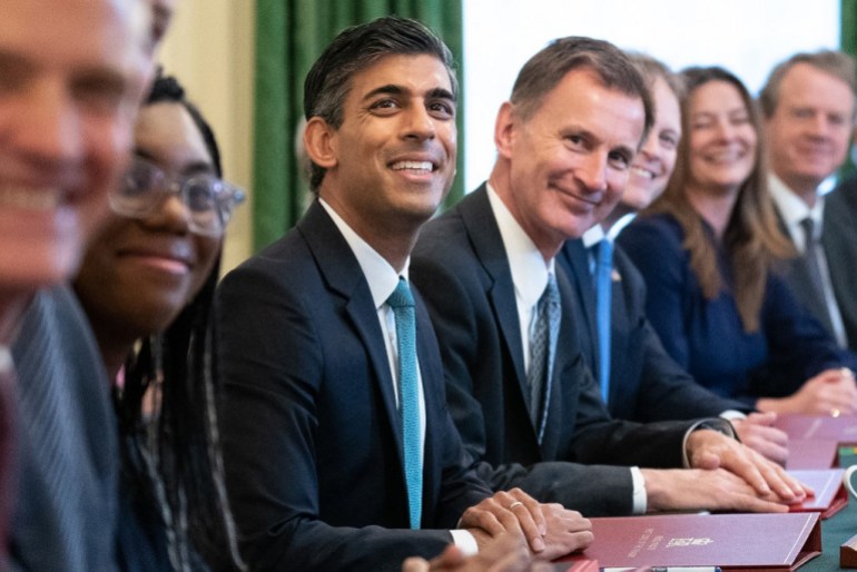 Britain's Prime Minister Rishi Sunak (C) poses for a photograph alongside his cabinet