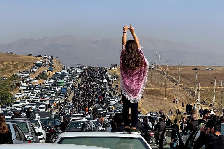 woman on car, arms raised