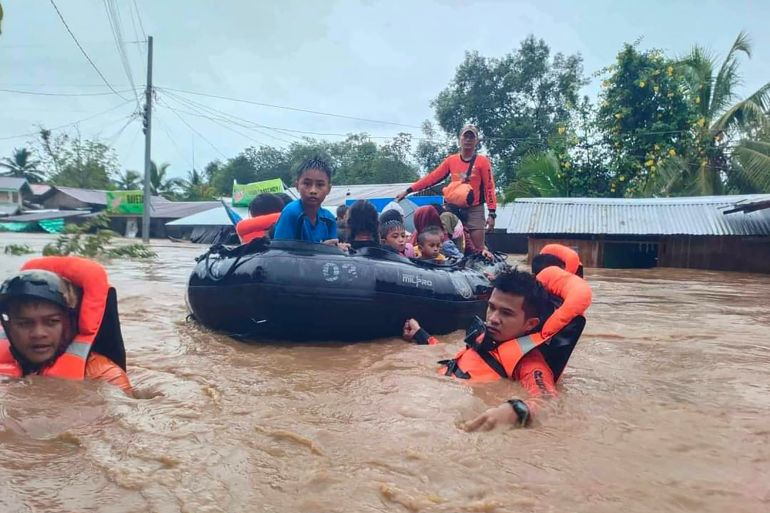 Rescue workers evacuating people from a flooded area due to heavy rain brought by Tropical Storm Nalgae in Parang, Maguindanao on October 28, 2022 [Philippine Coast Guard/AFP]