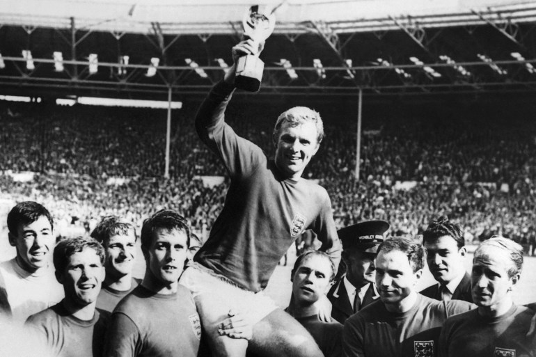 England's national soccer team captain Bobby Moore holds aloft the Jules Rimet trophy as he is carried by his teammates following England's victory over Germany