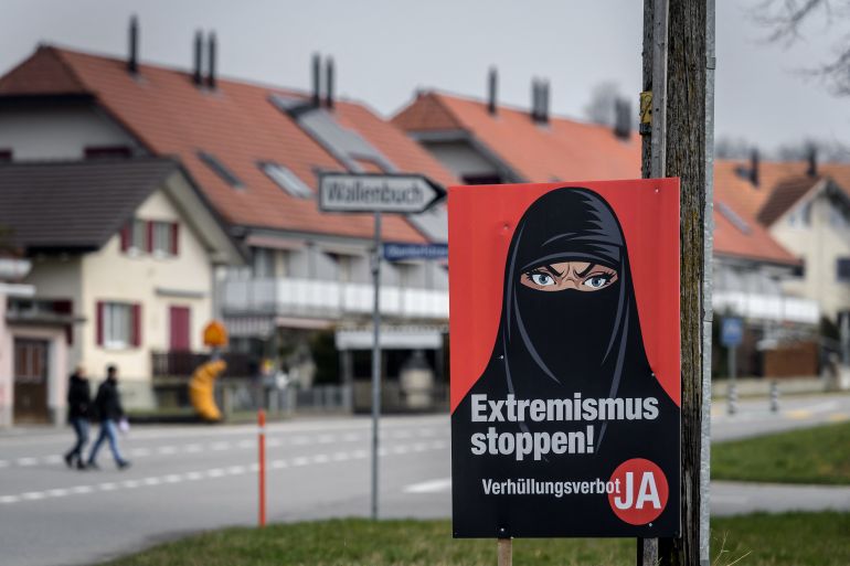 A campaign poster, in favour of the "burqa ban" initiative reading in German: "Stop extremism!" is seen in Biberen near Bern on March 7, 2021 as Switzerland voted on whether to ban full facial coverings in public places. - Swiss voters seemed on course to narrowly back a ban on full facial coverings in public places, with most referendum ballots counted. With results in from 22 of federal Switzerland's 26 cantons, 54 percent of voters were in favour of outlawing the burqa and the niqab. (Photo by Fabrice COFFRINI / AFP)