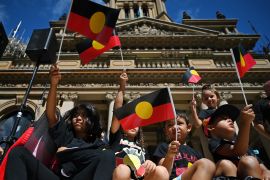 Children and young people wave Aboriginal flags during 2022's 'Invasion Day' rally
