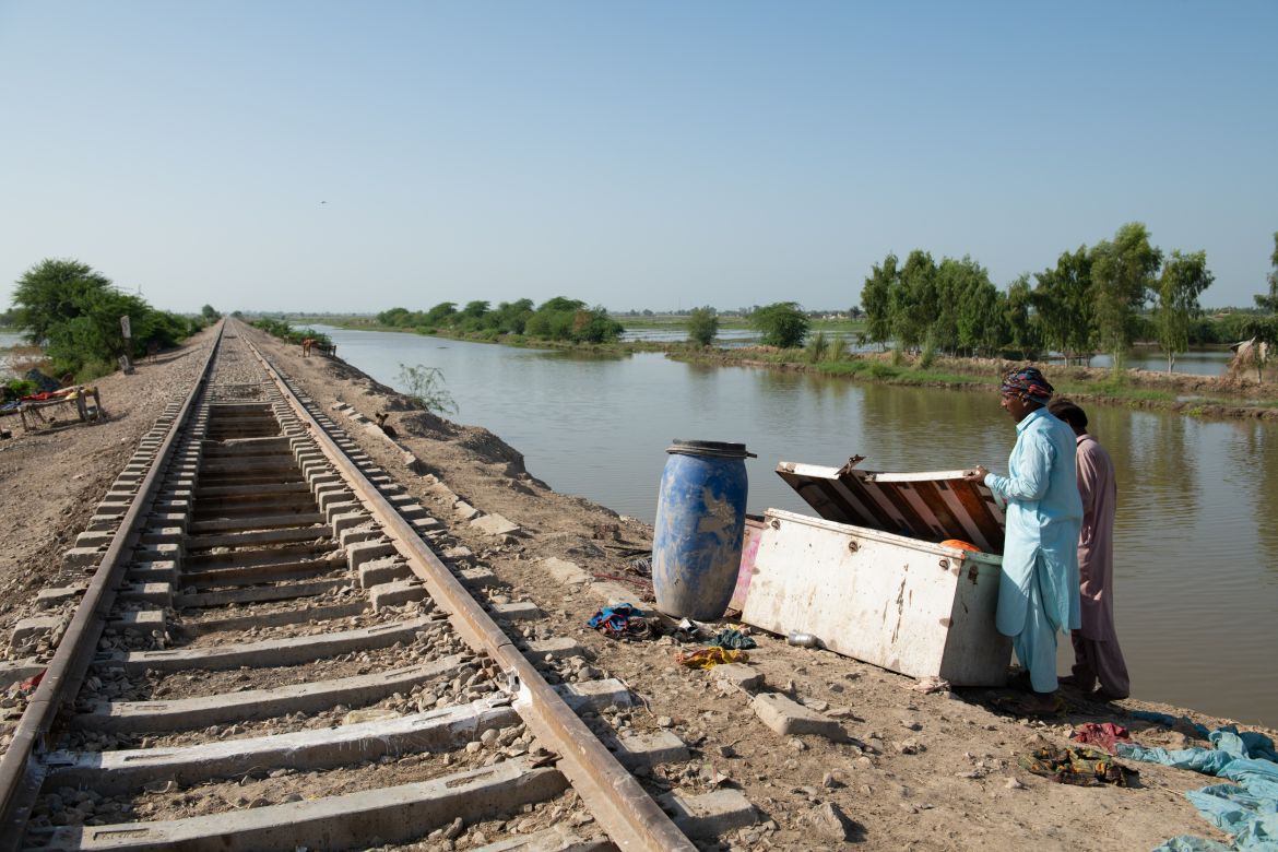 Other members of Kasim and Bibi’s community in Pir Bhakkar, seek shelter next to elevated railway tracks. Until recently, the family lived in a makeshift shelter there. When water levels began to slightly recede, they moved their shelter to the front yard of their home.