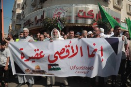 People in Gaza hold a banner
