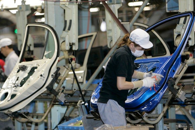 Employees of Nissan Motor Co work on an assembly line at the Oppama factory in Yokosuka, Japan.