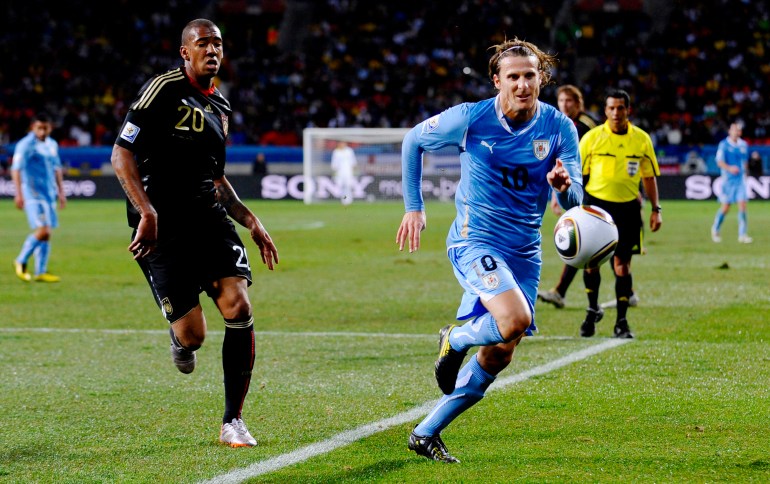 Diego Forlan and Germany's Jerome Boateng (L)